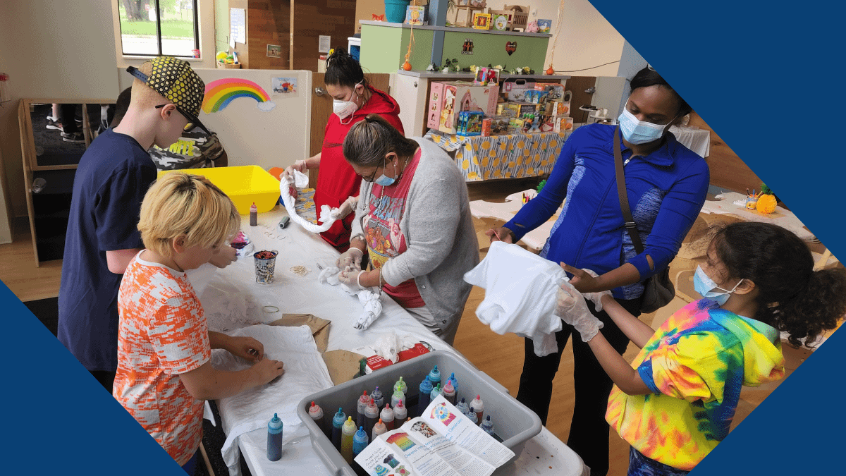 Parent and grandparent members of YWCA Kalamazoo’s Parent Advisory Committee gather with youth from the YWCA Children’s Center for a tie-dye event.